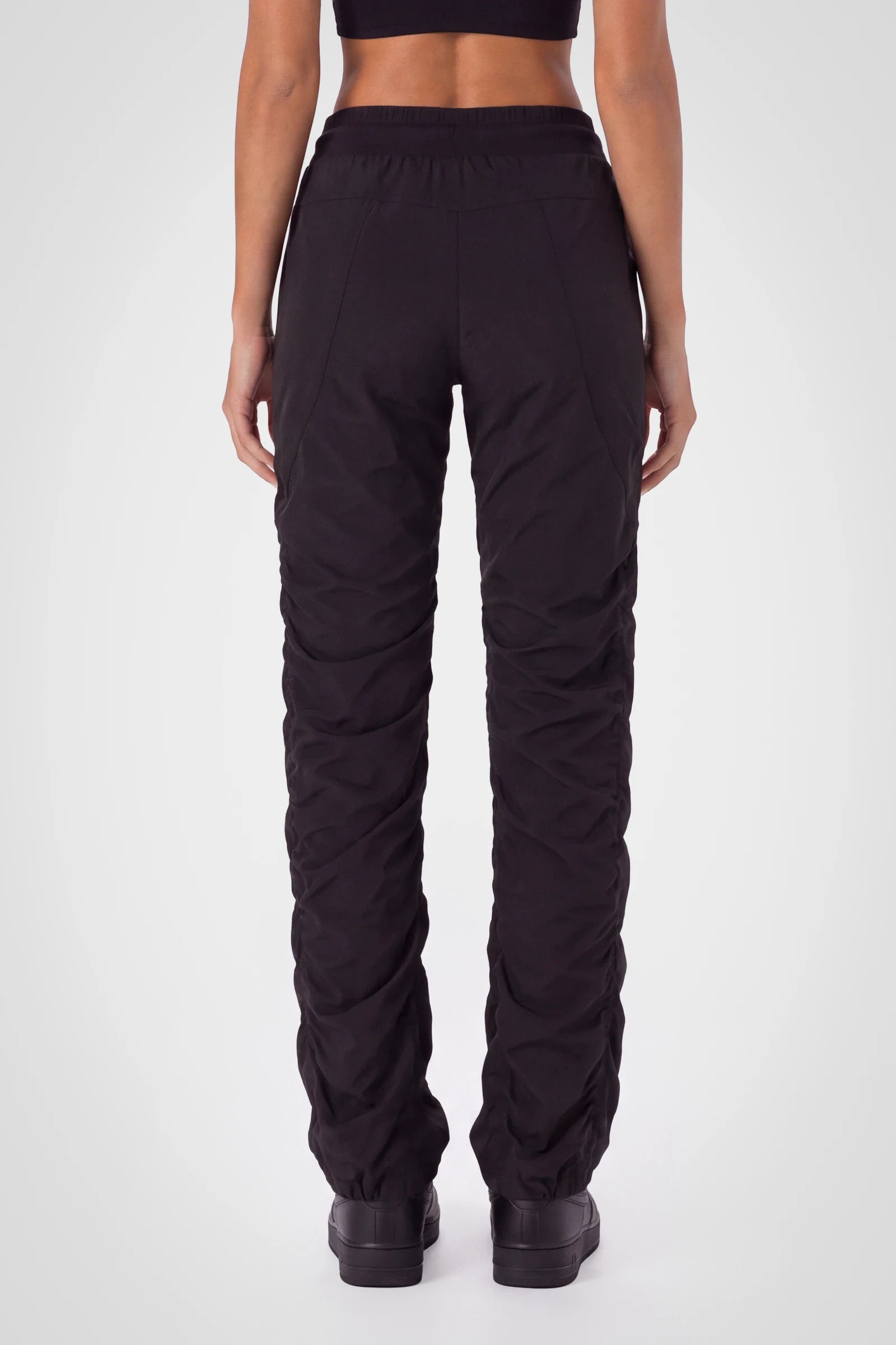 Women’s Black Adventurous Pant, rear three-quarter studio view showing the relaxed fit through the seat and gathered cuffs.