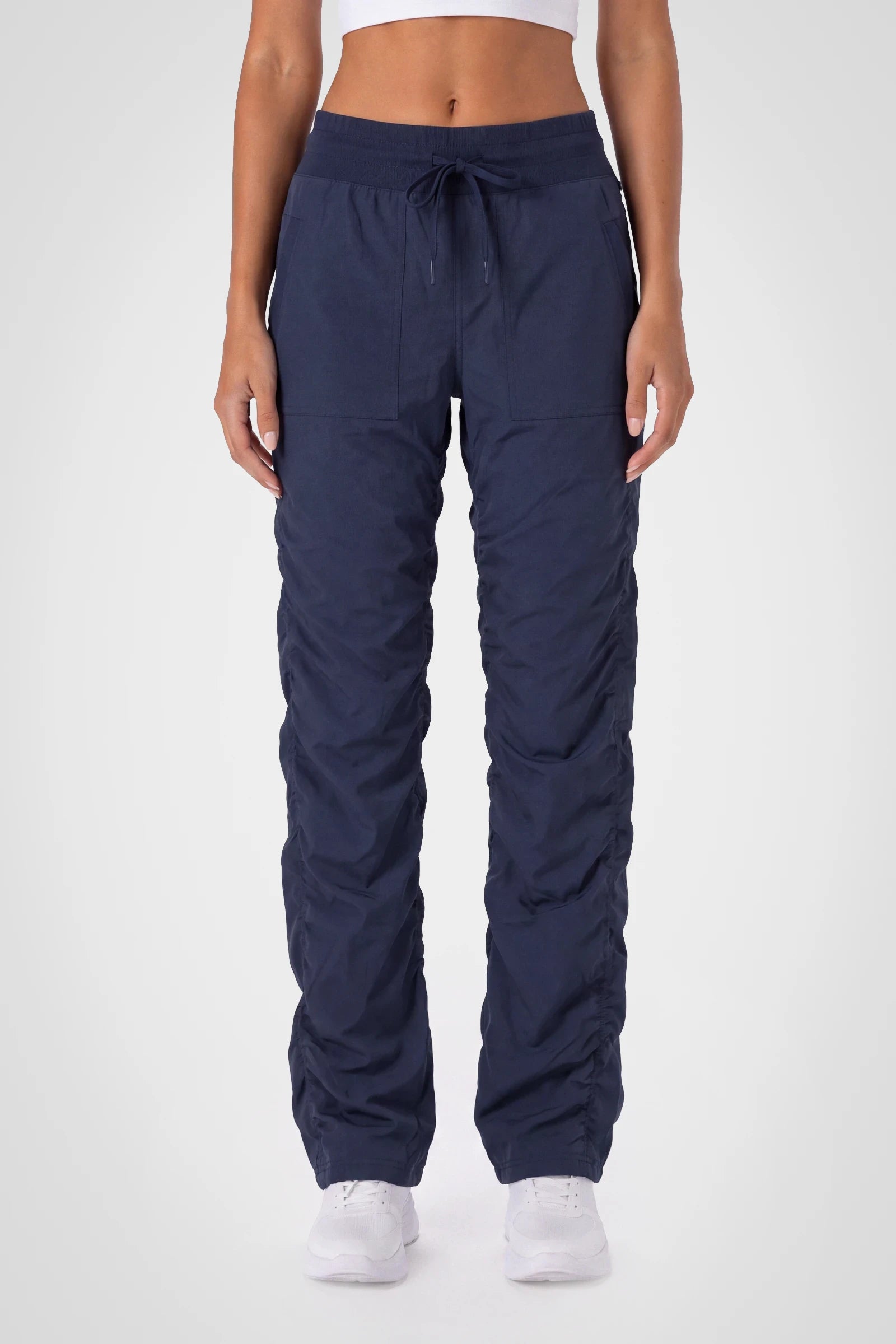 Women’s Navy Adventurous Pant, front studio view showing the elastic drawstring waist, utility patch pockets and gathered cuffs.
