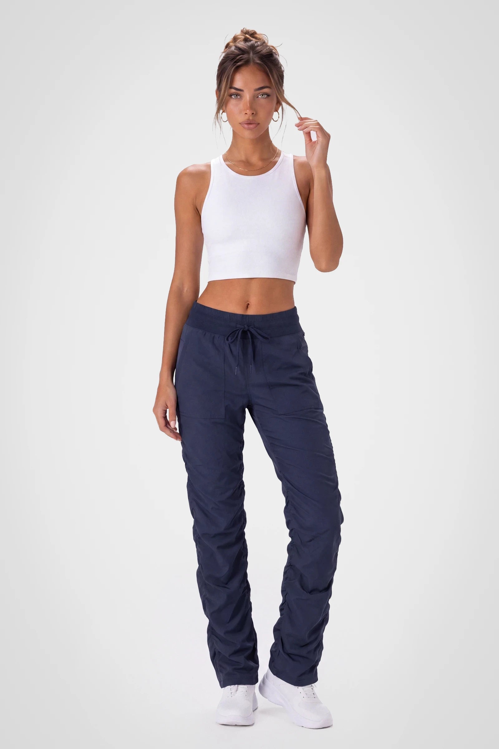 Women’s Navy Adventurous Pant, side studio view showing the relaxed tapered leg, patch pocket and gathered cuff.
