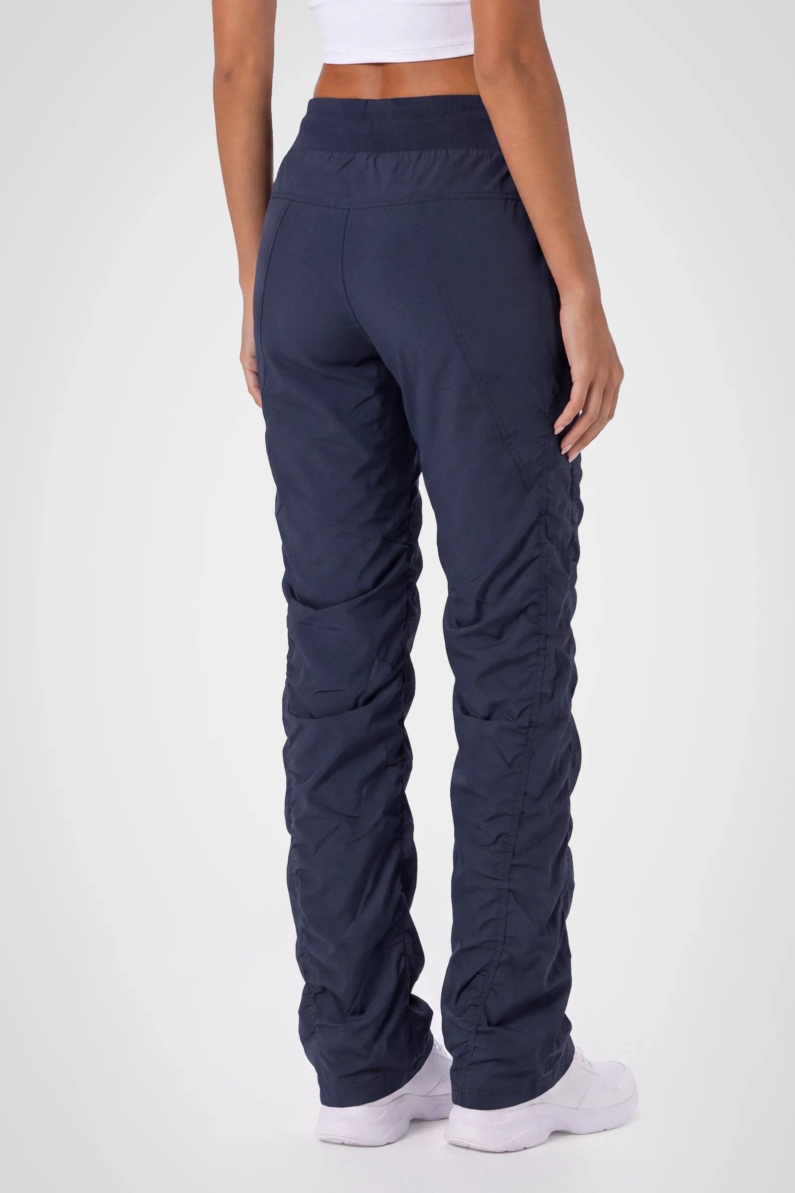 Women’s Navy Adventurous Pant, three-quarter studio view showing the tapered leg and gathered hem.